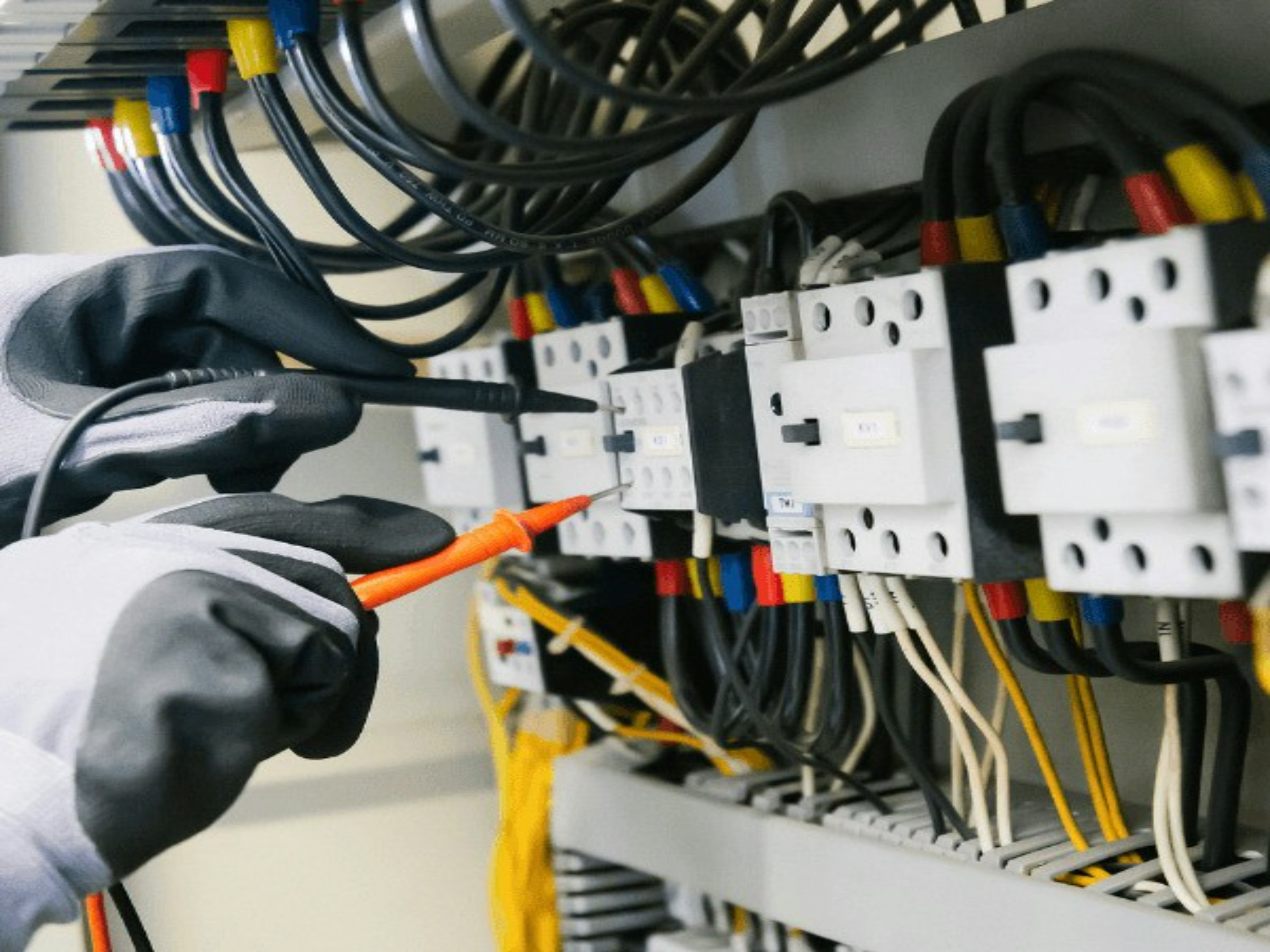 Electrician testing a distribution board with a multimeter